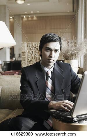Stock Image - Portrait of a businessman using a laptop. Fotosearch