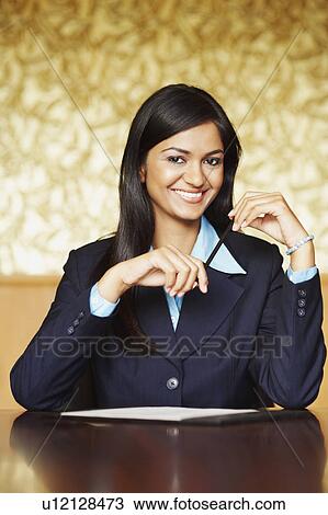 Portrait of a businesswoman holding a pencil and smiling View Large Photo Image Stock Image - Portrait of a businesswoman holding a pencil and smiling. Fotosearch