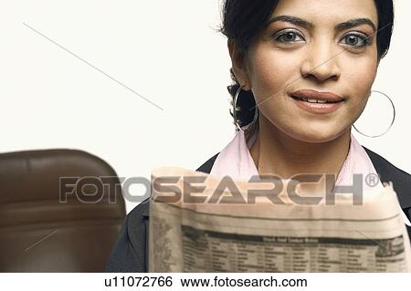Portrait of a businesswoman holding a newspaper View Large Photo Image Stock Photograph - Portrait of a businesswoman holding a newspaper. Fotosearch