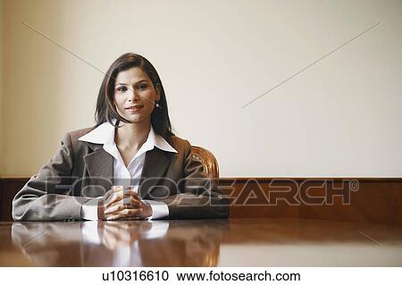Stock Image - Portrait of a businesswoman sitting in an office. Fotosearch