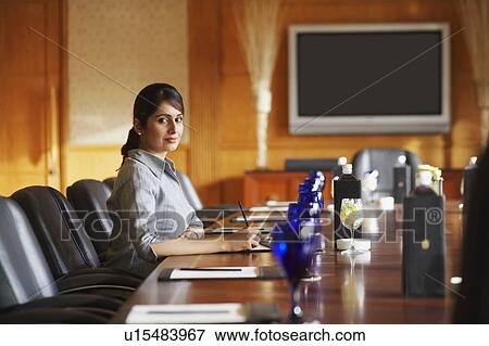 Portrait of a businesswoman sitting in a conference room and smiling View Large Photo Image Stock Photo - Portrait of a businesswoman sitting in a conference room and smiling. Fotosearch