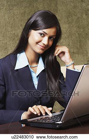 Portrait of a businesswoman using a laptop and smiling View Large Photo Image Stock Image - Portrait of a businesswoman using a laptop and smiling. Fotosearch