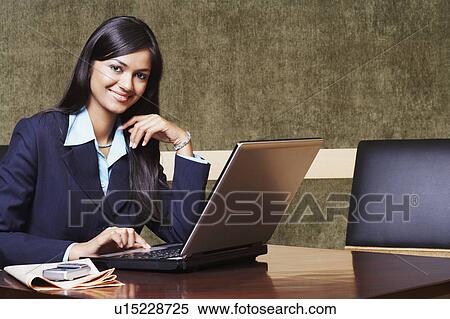 Portrait of a businesswoman using a laptop and smiling View Large Photo Image Stock Photography - Portrait of a businesswoman using a laptop and smiling. Fotosearch