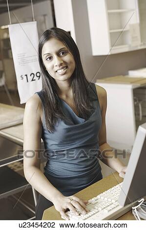 Stock Image - Portrait of a businesswoman working in an office. Fotosearch