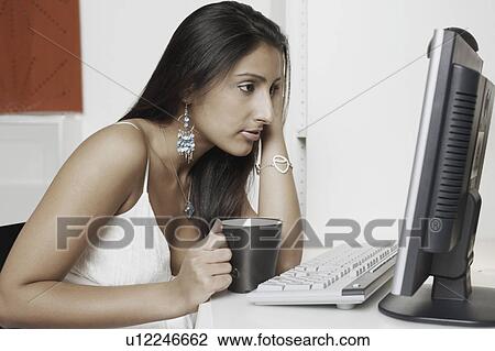 Side profile of a young woman looking at a computer monitor View Large Photo Image Stock Image - Side profile of a young woman looking at a computer monitor. Fotosearch