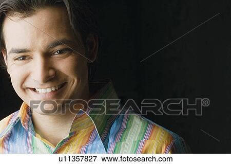 Close-up of a young man smiling View Large Photo Image Stock Photo - Close-up of a young man smiling. Fotosearch