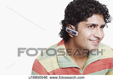 Close-up of a young man wearing a Bluetooth device View Large Photo Image Stock Photograph - Close-up of a young man wearing a Bluetooth device. Fotosearch