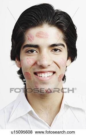 Stock Photo - Portrait of a young man covered in lipstick kisses. Fotosearch