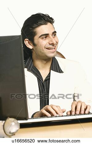 Stock Image - Close-up of a businessman laughing in front of a computer. Fotosearch