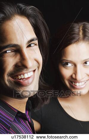 Close-up of a young couple smiling View Large Photo Image Stock Image - Close-up of a young couple smiling. Fotosearch