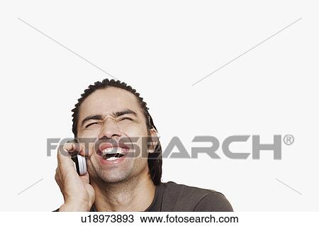 Close-up of a young man talking on a mobile phone and laughing View Large Photo Image Stock Image - Close-up of a young man talking on a mobile phone and laughing. Fotosearch