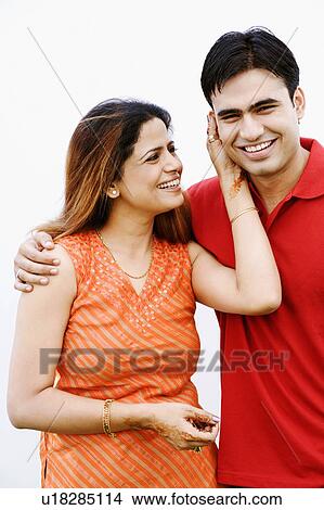 Portrait of a young woman pulling the ear of a mid adult man and smiling View Large Photo Image Picture - Portrait of a young woman pulling the ear of a mid adult man and smiling. Fotosearch