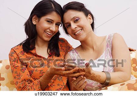 Stock Photo - Portrait of a young woman smiling with a mid adult woman. Fotosearch
