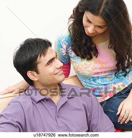 Stock Photograph - Close-up of a young couple looking at each other and smiling. Fotosearch