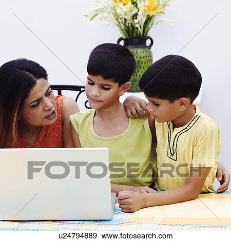 Mid adult woman with her two sons using a laptop View Large Photo Image Stock Photo - Mid adult woman with her two sons using a laptop. Fotosearch