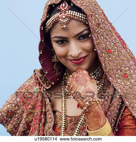 Portrait of a bride in a traditional wedding dress smiling with her hand on her chin View Large Photo Image Picture - Portrait of a bride in a traditional wedding dress smiling with her hand on her chin. Fotosearch