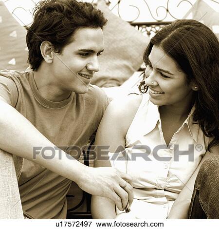 Stock Photo - Close-up of a young couple looking at each other and smiling. Fotosearch