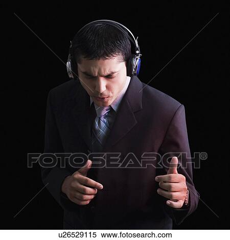 Close-up of a young man wearing headphones and listening to music View Large Photo Image Stock Photography - Close-up of a young man wearing headphones and listening to music. Fotosearch