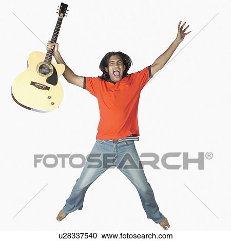 Stock Image - Portrait of a young man holding a guitar and shouting. Fotosearch