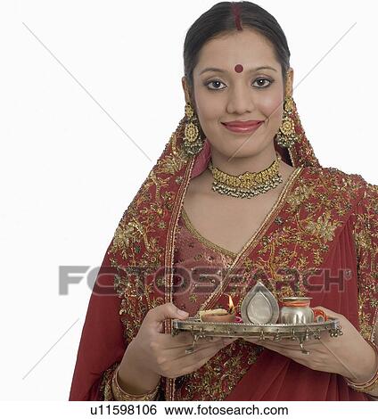 Portrait of a young woman holding a plate of religious offerings View Large Photo Image Stock Photograph - Portrait of a young woman holding a plate of religious offerings. Fotosearch