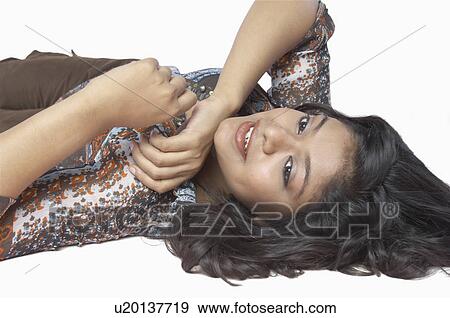Stock Photo - Close-up of a young woman lying on the floor and smiling. Fotosearch