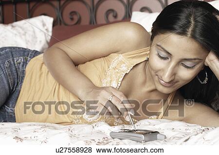 Close-up of a young woman using a mobile phone View Large Photo Image Stock Photo - Close-up of a young woman using a mobile phone. Fotosearch