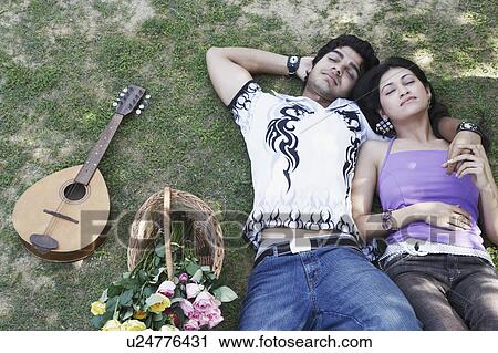 High angle view of a young couple lying together in the park View Large Photo Image Stock Image - High angle view of a young couple lying together in the park. Fotosearch