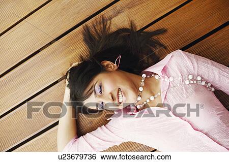 Stock Photograph - High angle view of a young woman smiling. Fotosearch