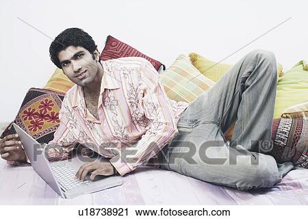 Stock Image - Portrait of a young man using a laptop. Fotosearch