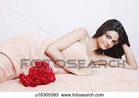 Portrait of a young woman in a towel lying on the bed View Large Photo Image Stock Image - Portrait of a young woman in a towel lying on the bed. Fotosearch