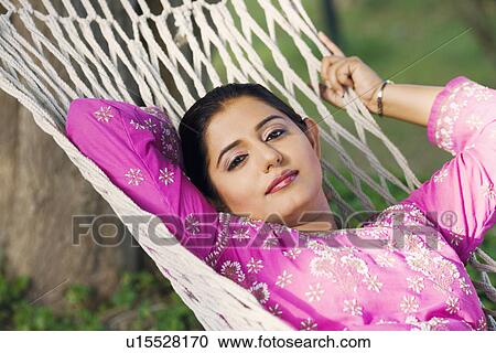 Stock Image - Portrait of a young woman lying in a hammock. Fotosearch
