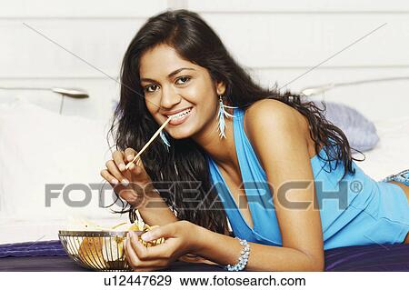 Portrait of a young woman lying on the bed and smiling View Large Photo Image Stock Photo - Portrait of a young woman lying on the bed and smiling. Fotosearch