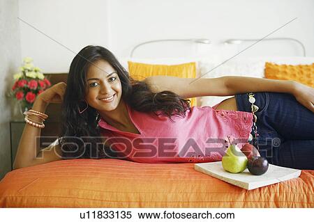 Portrait of a young woman lying on the bed and smiling View Large Photo Image Stock Photography - Portrait of a young woman lying on the bed and smiling. Fotosearch