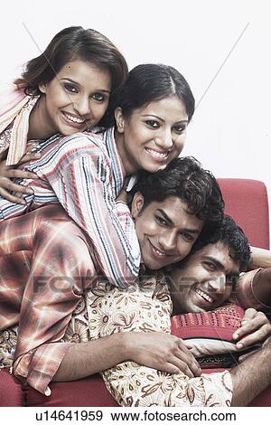 Portrait of two young men and two young women lying on top of each other smiling View Large Photo Image Stock Photo - Portrait of two young men and two young women lying on top of each other smiling. Fotosearch