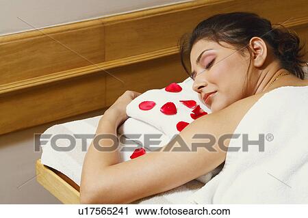 Rear view of a young woman lying on a massage table View Large Photo Image Stock Image - Rear view of a young woman lying on a massage table. Fotosearch