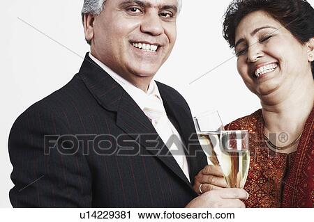 Close-up of a mature couple toasting with champagne flutes View Large Photo Image Stock Image - Close-up of a mature couple toasting with champagne flutes. Fotosearch