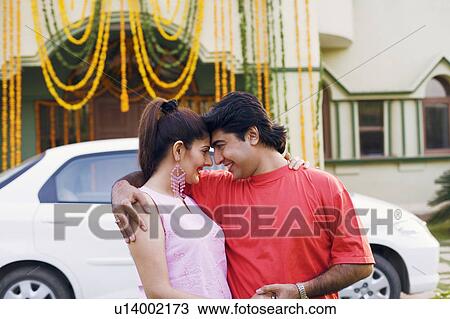 Close-up of a young couple embracing each other and smiling View Large Photo Image Stock Image - Close-up of a young couple embracing each other and smiling. Fotosearch