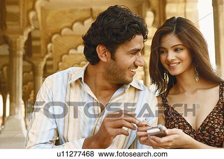 Close-up of a young couple looking at a each other and smiling, Agra Fort, Agra, Uttar Pradesh, India View Large Photo Image Stock Photo - Close-up of a young couple looking at a each other and smiling, Agra Fort, Agra, Uttar Pradesh, India. Fotosearch