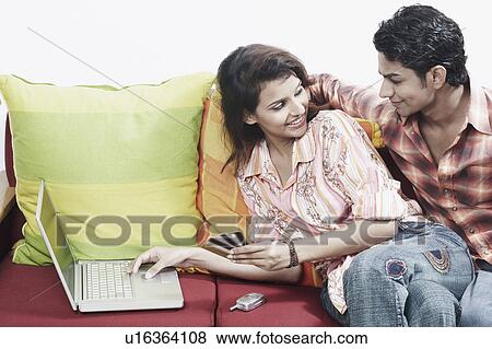 Close-up of a young couple looking at each other smiling View Large Photo Image Stock Photo - Close-up of a young couple looking at each other smiling. Fotosearch