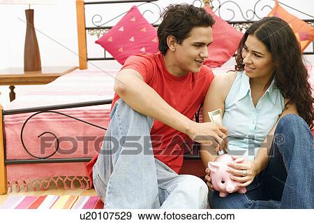 Stock Photo - Close-up of a young couple looking at each other and smiling. Fotosearch