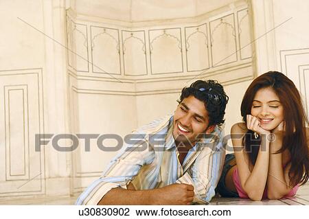 Stock Image - Close-up of a young couple lying on the floor. Fotosearch