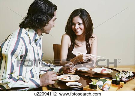 Close-up of a young couple sitting and talking at the dining table View Large Photo Image Stock Image - Close-up of a young couple sitting and talking at the dining table. Fotosearch