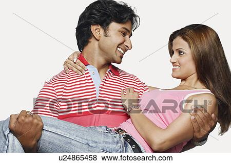 Stock Photo - Close-up of a young man carrying a young woman. Fotosearch