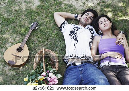 High angle view of a young couple lying together in the park View Large Photo Image Stock Photography - High angle view of a young couple lying together in the park. Fotosearch