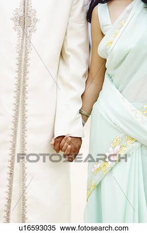 Mid section view of a young couple holding hands View Large Photo Image Stock Photography - Mid section view of a young couple holding hands. Fotosearch