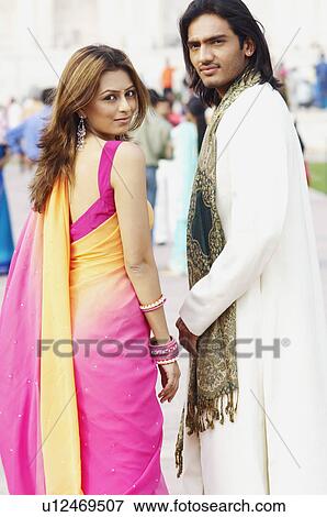 Stock Photo - Portrait of a young couple in front of a mausoleum, Taj Mahal, Agra, Uttar Pradesh, India. Fotosearch