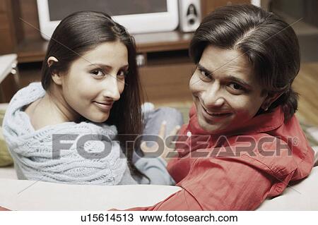 Portrait of a young couple sitting on a couch View Large Photo Image Stock Image - Portrait of a young couple sitting on a couch. Fotosearch