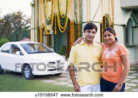 Portrait of a young couple standing in front of a decorated house View Large Photo Image Stock Photo - Portrait of a young couple standing in front of a decorated house. Fotosearch