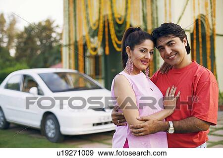 Portrait of a young couple standing in front of a decorated house and smiling View Large Photo Image Stock Photo - Portrait of a young couple standing in front of a decorated house and smiling. Fotosearch