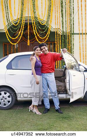 Portrait of a young couple standing near the open door of a car and smiling View Large Photo Image Stock Image - Portrait of a young couple standing near the open door of a car and smiling. Fotosearch